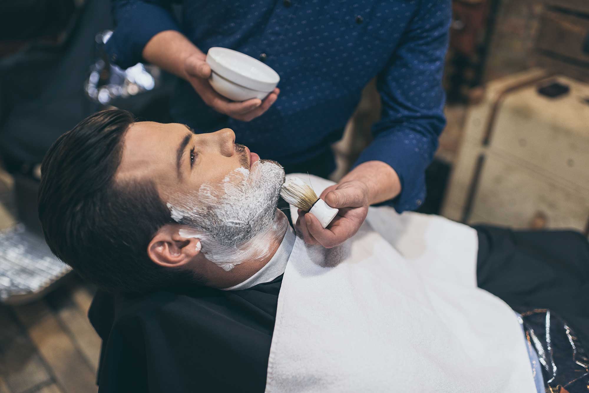 barber-applying-foam-before-shaving-of-customer-in-2022-12-16-17-03-17-utc.jpg